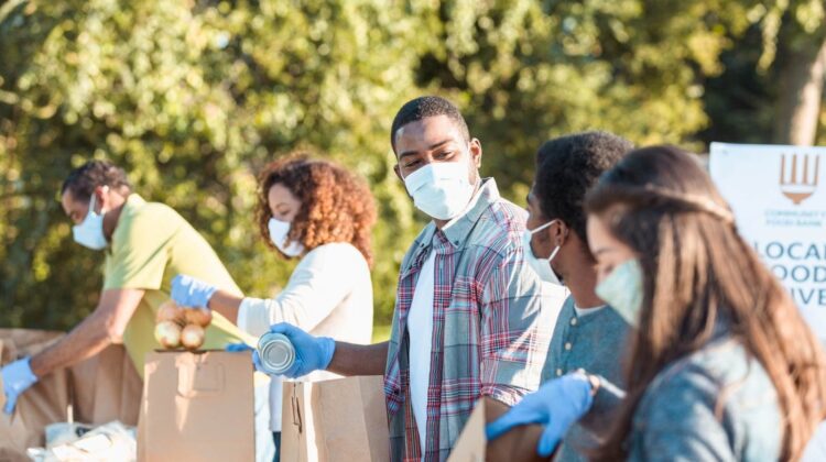 Volunteers in masks passing out food