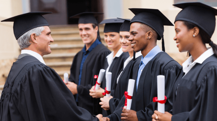 male professor shaking college graduate hands