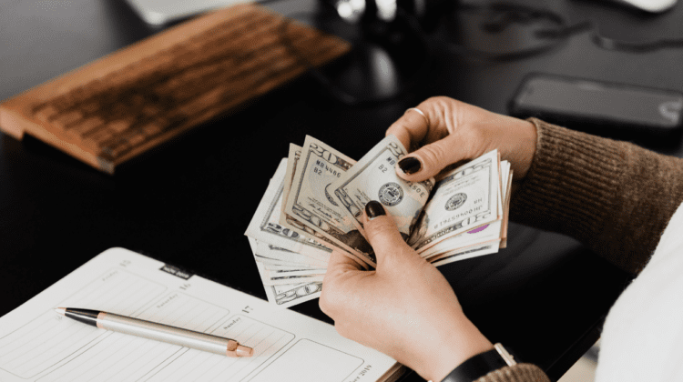 Women shifting through a stack of dollars